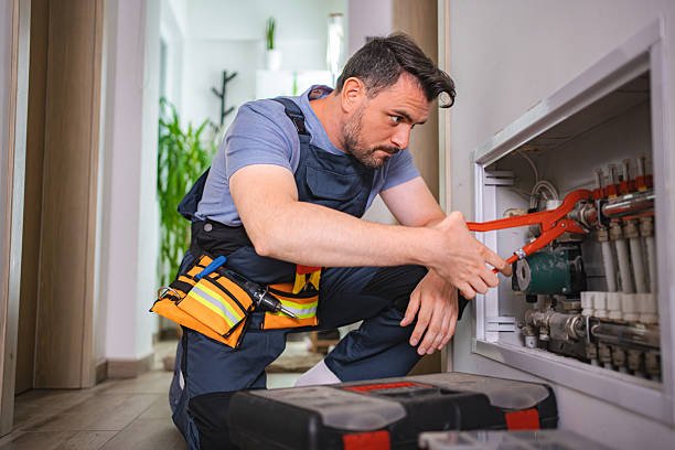 فني سباكة يفحص توصيلات المياه داخل أحد العقارات